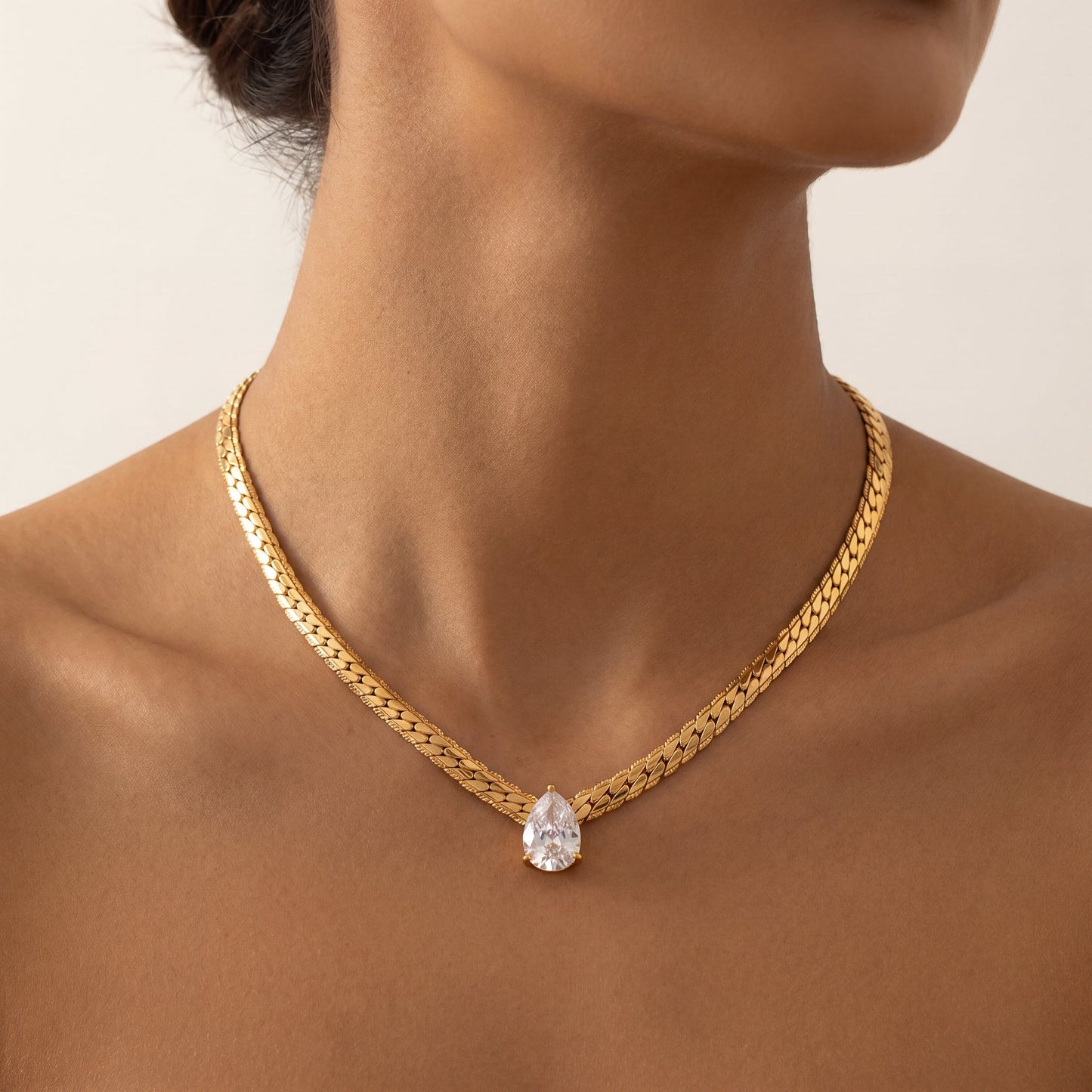 Goutte Necklace by VELTRĀ, close-up of gold chain and crystal pendant